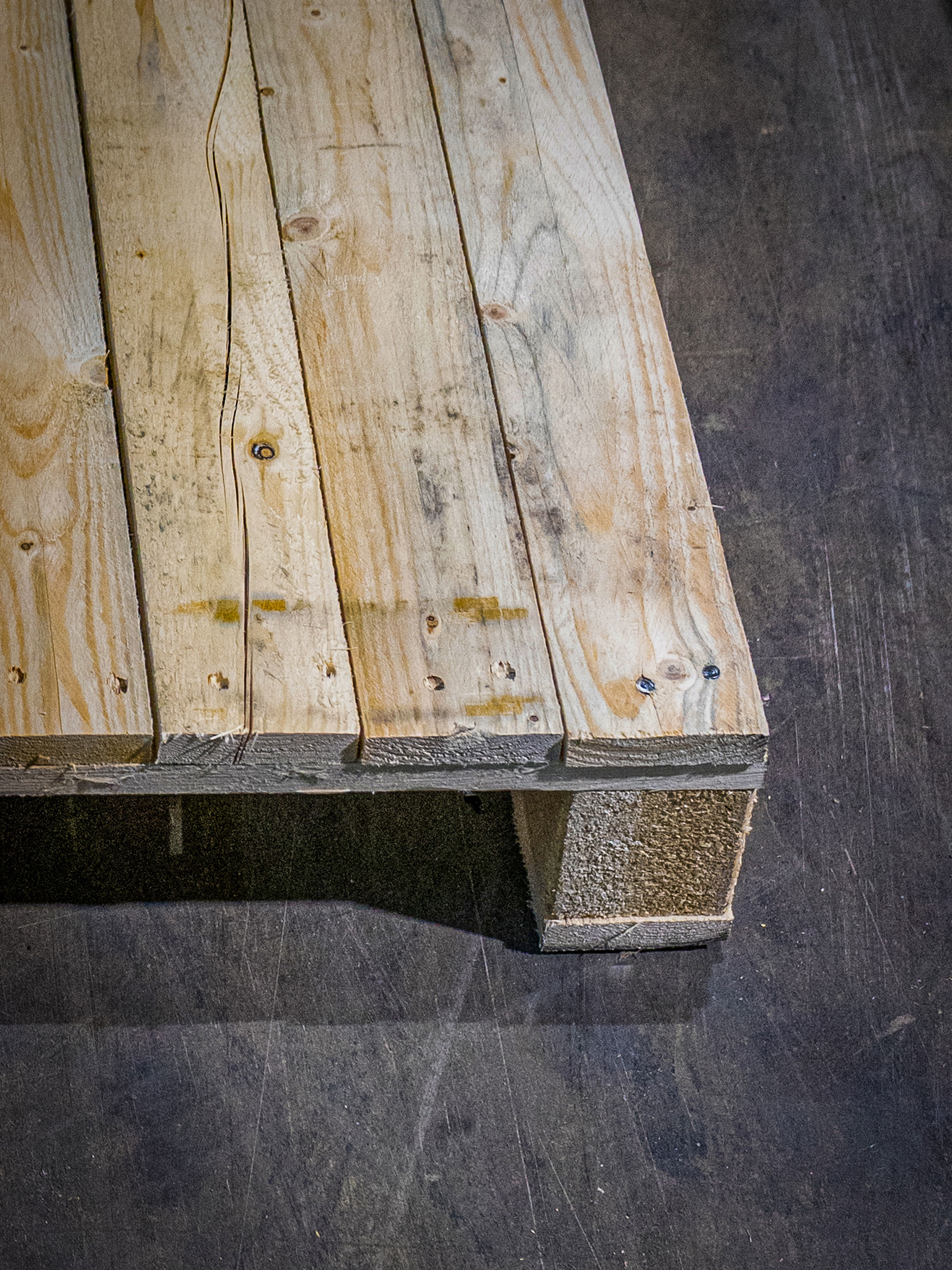 Schmuckbild einer in Szene gesetzten Europalette aus Holz im E.P.H. Schmidt-Lager om Dortmund. Der Untergrund ist dunkelgrau.