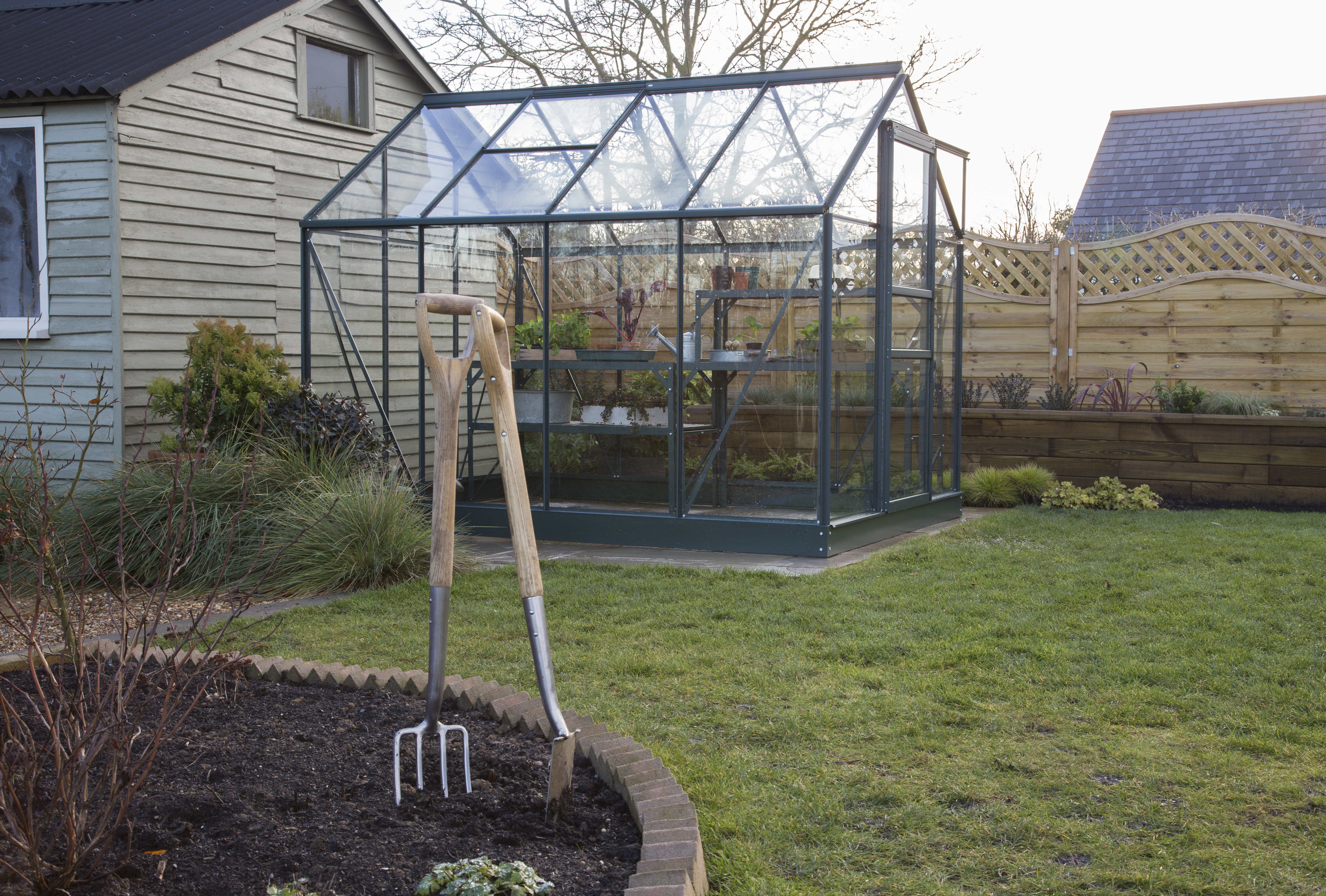 Gewächshaus, Garten, im Winter, diesiges Wetter, Hacke und Schaufel im Vordergurnd